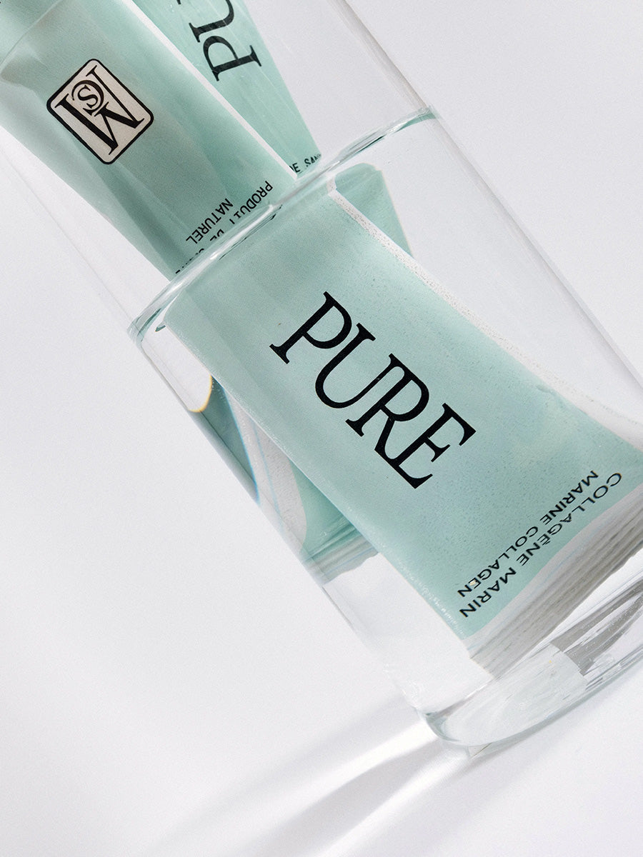 sachet pure collagène marin mcs vu à travers un verre d’eau claire