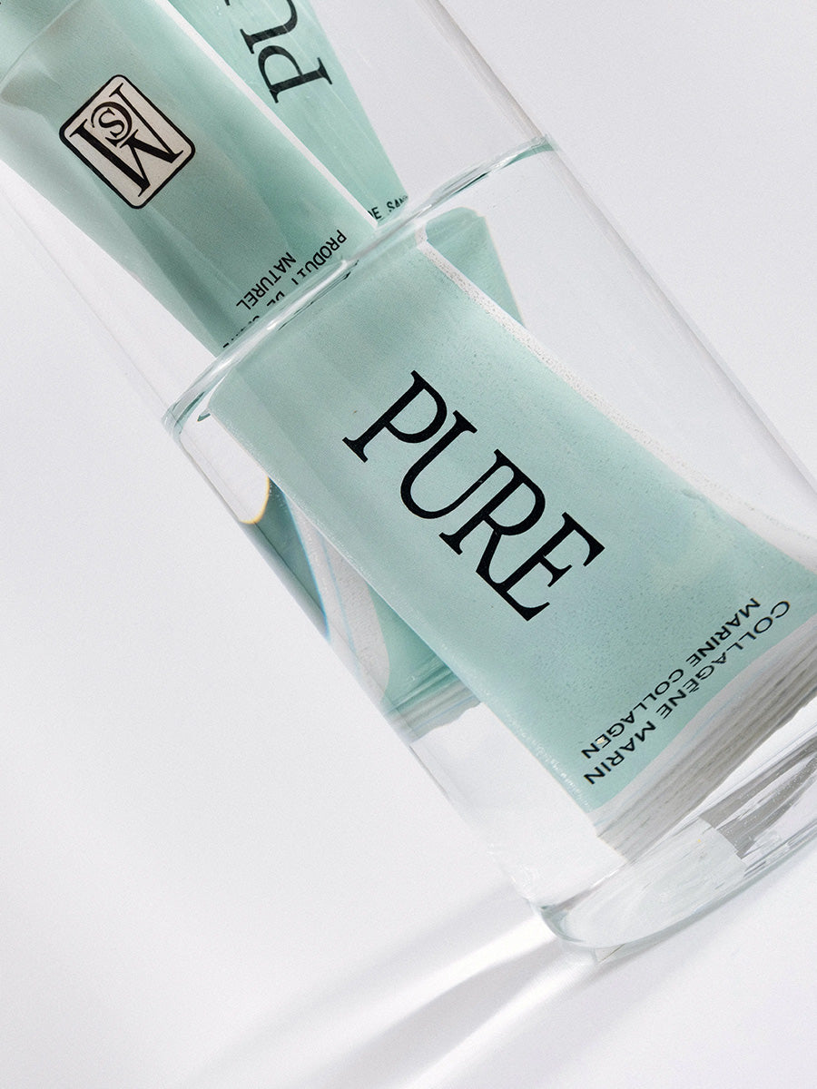 sachet pure collagène marin mcs vu à travers un verre d’eau claire